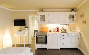 a kitchen with white cabinets and a stove at Friendly Home Doppel-Doppelappartement Union in Bornheim