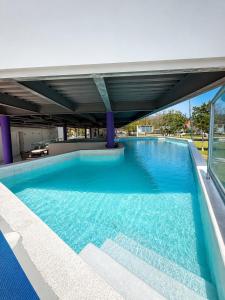 a swimming pool with blue water in a building at AM Hotel y Plaza in Santa Cruz Huatulco