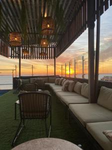 a row of white couches on a patio with the ocean at Hotel Sun in Encarnación