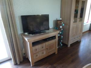 a flat screen tv sitting on top of a wooden entertainment center at Brouckmolen in Alveringem