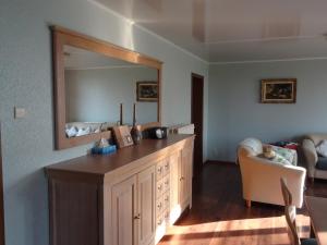 a bathroom with a wooden dresser with a mirror at Brouckmolen in Alveringem