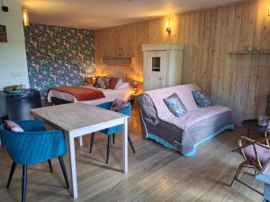 a room with a bed and a couch and a table at La Maison des Senteurs in Francorchamps