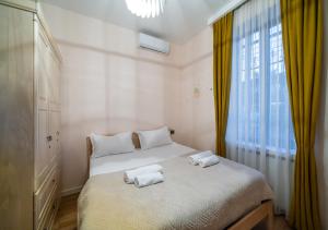 a white bedroom with two towels on a bed at Niabi 3BDR Villa with pool in Tbilisi City +42 photos