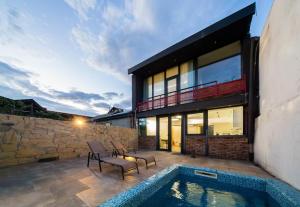 a house with a swimming pool next to a stone wall at Niabi 3BDR Villa with pool in Tbilisi City