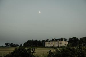 an old house in a field with trees in the background at Moulin de Micheline - Jacuzzi - Vue Exceptionnelle in Bourg-dʼIré