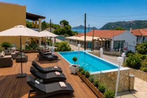 a deck with lounge chairs and a swimming pool at San Georgio Hotel in Agios Georgios Pagon