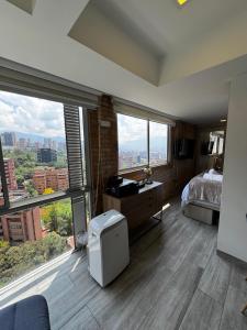a bedroom with a bed and large windows at 2201 Hermoso apartamento poblado in Medellín