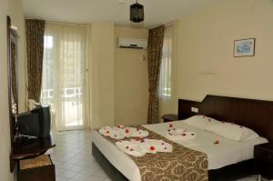 ein Hotelzimmer mit zwei Betten und einem Fernseher in der Unterkunft Bariscan Hotel in Mahmutlar