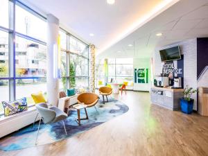 an office with chairs and a table and a room with windows at ibis budget Warszawa Centrum in Warsaw