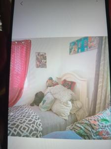 a child laying on a bed with two teddy bears at Rest &Rejoice in Bamboo Market