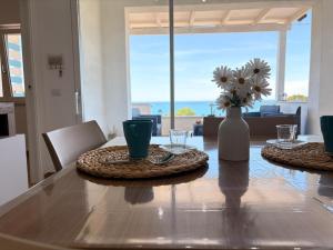 a dining room table with a vase of flowers on it at Circe Casa Vacanze in San Menaio