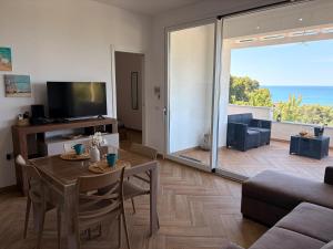 a living room with a table and a view of the ocean at Circe Casa Vacanze in San Menaio