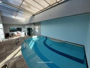 a large swimming pool in a large room at Flat Moderno c/ Vista Próx. PUC, Allianz, Pacaembu in São Paulo