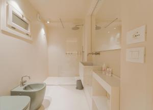 a white bathroom with a sink and a toilet at Albergo Egadi in Favignana +34 photos