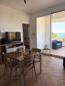 a living room with a table and chairs and a television at Circe Casa Vacanze in San Menaio