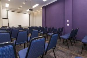 a room with purple walls and blue chairs and a whiteboard at Flat Moderno c/ Vista Próx. PUC, Allianz, Pacaembu in São Paulo +49 photos