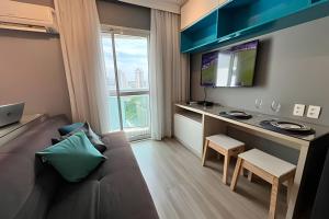a small living room with a couch and a desk at Flat Moderno c/ Vista Próx. PUC, Allianz, Pacaembu in São Paulo