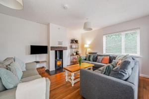 a living room with two couches and a fireplace at Saltwater, East Wittering in East Wittering