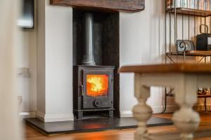 a wood stove in a room with a table at Saltwater, East Wittering in East Wittering +26 photos