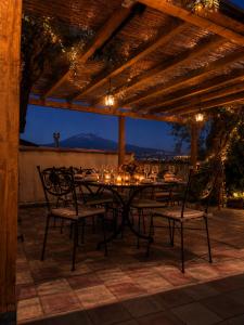 a table and chairs on a patio at night at Il Piccolo Aranceto in Motta SantʼAnastasia