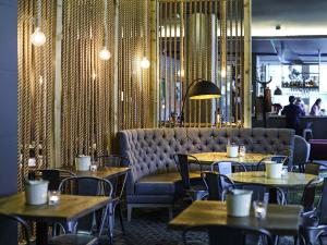 a restaurant with tables and chairs and a couch at Novotel Liverpool Centre in Liverpool