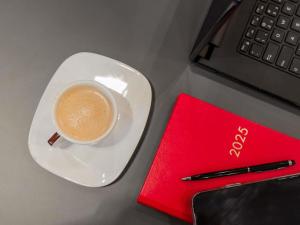 a cup of coffee on a plate next to a keyboard at ibis Navegantes Itajai in Itajaí +160 photos