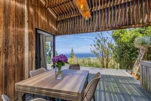 a vase of purple flowers on a table on a deck at GuestReady - Casa do Horizonte in Mosteiros