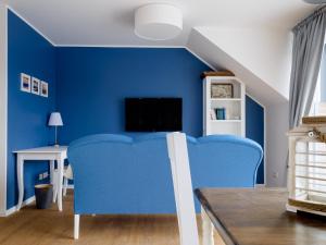 a blue living room with a blue couch and a tv at Zweitraum in Oldenburg in Oldenburg