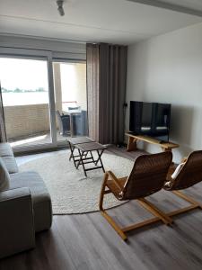 a living room with a couch and a tv at Strandappartement Iselmar Makkum nr 30 in Makkum