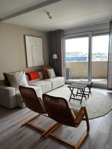 a living room with a couch and a table and chairs at Strandappartement Iselmar Makkum nr 30 in Makkum