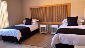 a hotel room with two beds and a window at The Pebbles-Unit-1 in Mahikeng
