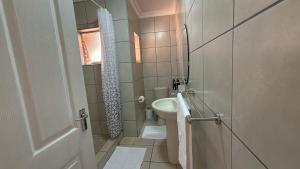 a small bathroom with a toilet and a sink at The Pebbles-Unit-1 in Mahikeng +4 photos