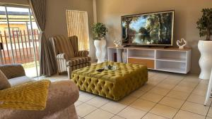 a living room with a couch and a tv at The Pebbles-Unit-1 in Mahikeng