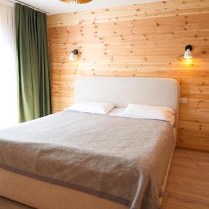 a bedroom with a bed with a wooden wall at Silence Houses in Tossor