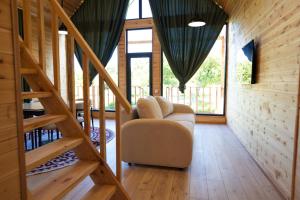 a room with a staircase with a chair and a stair case at Silence Houses in Tossor