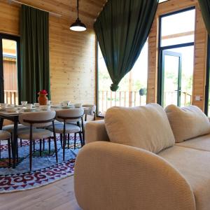a living room with a couch and a table with chairs at Silence Houses in Tossor