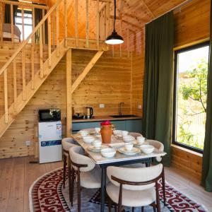 a dining room with a table with chairs and a staircase at Silence Houses in Tossor +19 photos