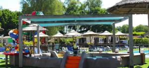 a resort with a pool with chairs and umbrellas at Huisje 11 in Enschede
