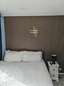 a bedroom with a white bed and a wooden wall at 52 strawberry in Hayle +13 photos