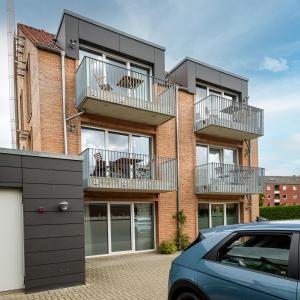 an apartment building with balconies and a car parked in front at Zweitraum in Oldenburg in Oldenburg