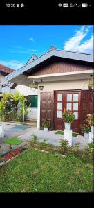 a house with two garage doors and two potted plants at Apartman Darija in Vrnjci