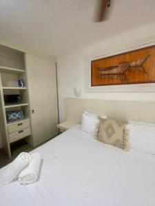 a bedroom with a white bed and a cabinet at Isla Lorens in Isla Mujeres