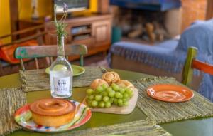 a table with bread and grapes and a glass bottle at Casa Bosque Encantador in Rancho Queimado