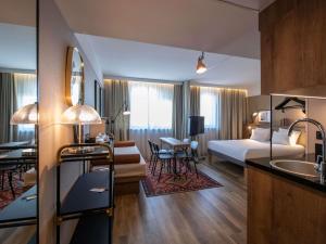 a hotel room with a bed and a living room at Novotel Suites Nice Airport in Nice +168 photos
