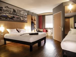 a hotel room with two beds and a desk at ibis Cannes Mandelieu in Mandelieu-La Napoule +118 photos