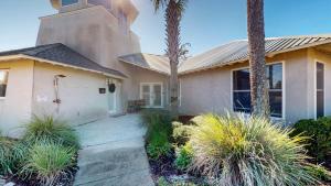 a church with palm trees in front of a house at Lighthouse Unit B in Jekyll Island