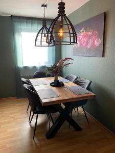 a dining room table with chairs and two lights at Ferienwohnung Sankt Michael in Bad Laasphe