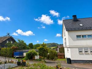 a white house with a blue sky in the background at Ferienwohnung Sankt Michael in Bad Laasphe