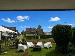 a group of white chairs sitting in the grass at Ferienwohnung Sankt Michael in Bad Laasphe +9 photos