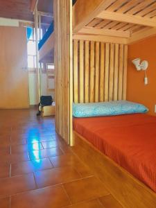 a bedroom with a bed with a red bedspread at Arpegio Hostel in San Rafael